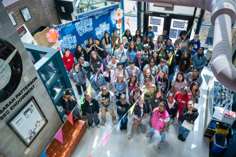 An overhead picture of a group of young girls inside a laboratory