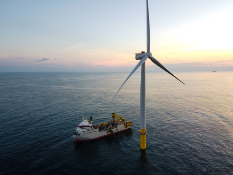A wind turbine installation vessel beside a 6-megawatt turbine