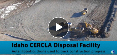An aerial view taken by a drone of a large gravel area with work vehicles