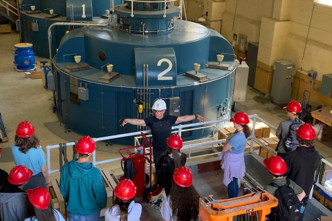 Aerial view of people in hardhats looking towards turbines inside the Rocky Reach Dam