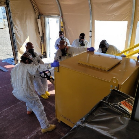 Employees in hazmat suits carrying out work