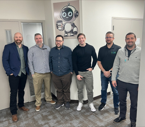 A group of employees smiling for a group photo