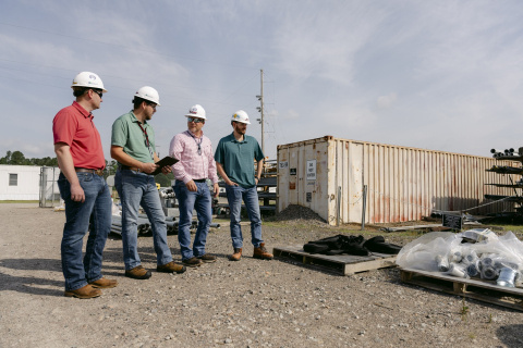 A group of employees in white hard hats surveying the land on the Savannah River Site