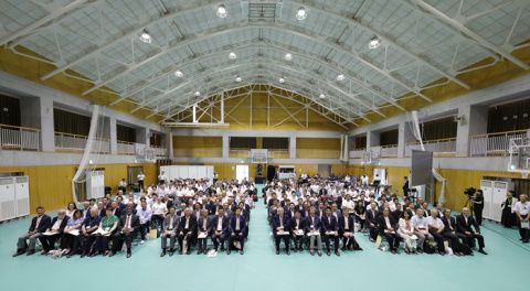 A large crowd of attendees sitting in chairs at a forum in Japan