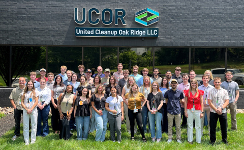 A large group photo of interns outside of the UCOR building