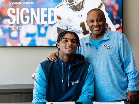 Cam Ward signing for the Tennessee Titans alongside his father, Calvin.