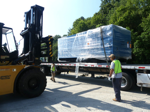 A large package on the back of a truck being lifted by a forklifted
