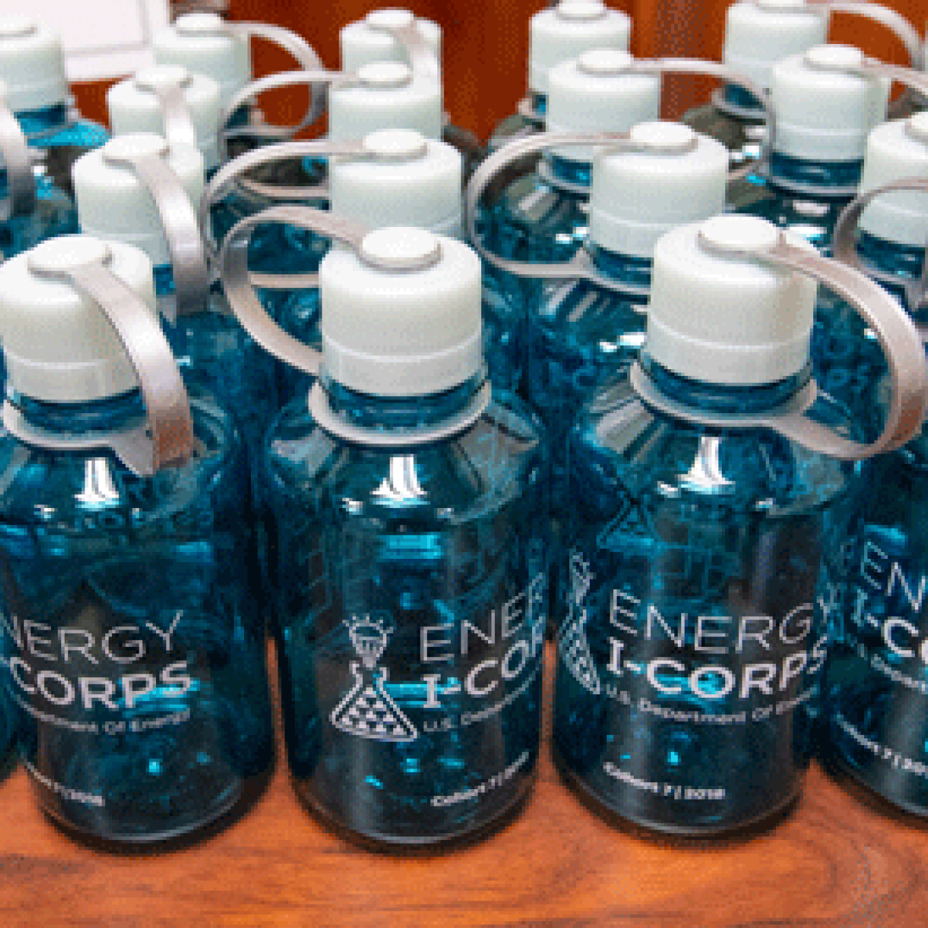 A line of water bottles with the Energy I-Corps logo on their sides