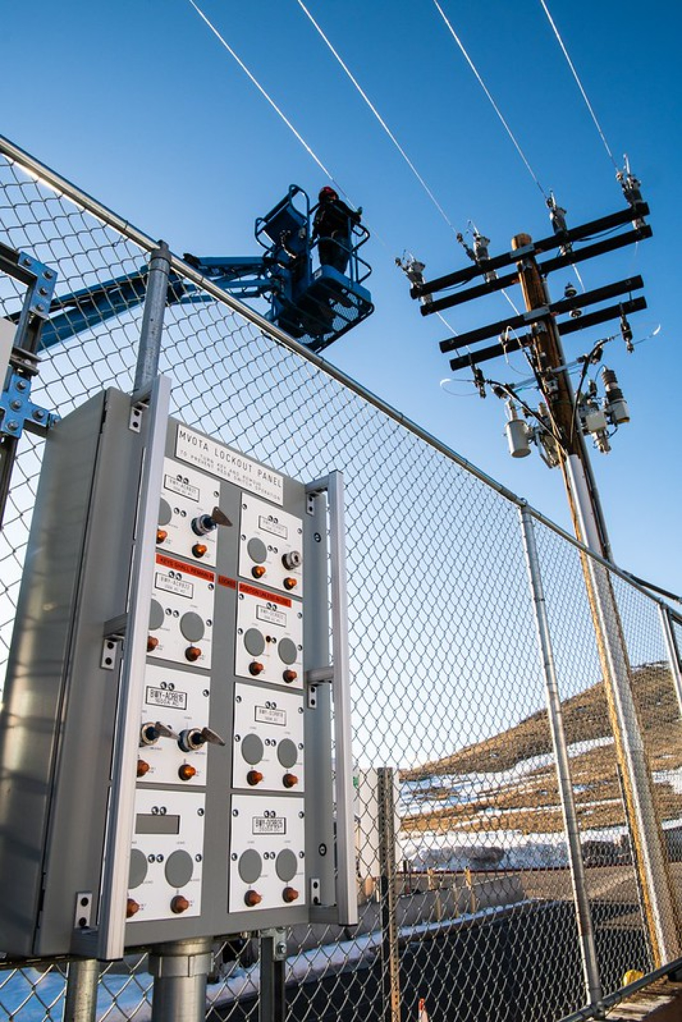 Researchers on a bucket truck install sensors on distribution lines.