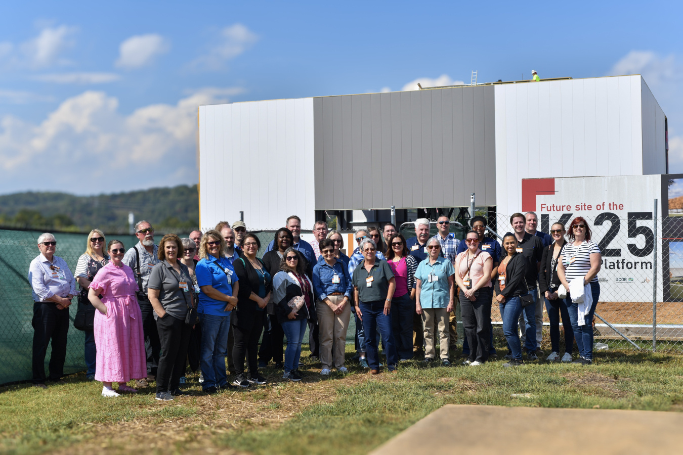 A group of people pose outside for a picture in front of a large white building
