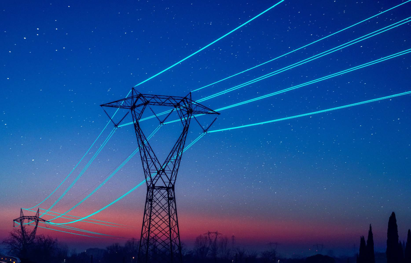 Illuminated power lines in night sky