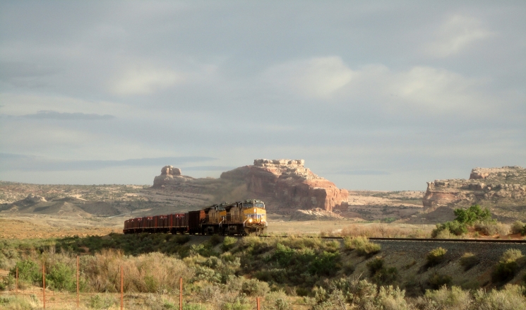 In the 1950s, one of the largest uranium deposits in the U.S. was found near Moab, Utah. The Department of Energy began cleaning up the uranium mill tailings from the Moab Site in April 2009, using steel containers to transport more than five million tons of tailings for safe disposal near Crescent Junction, Utah. In this May 2012 photo, one of the trains is shown on the Union Pacific Railroad in Utah, passing a butte capped by a familiar southwest U.S. rock formation known as Navajo Sandstone. | Photo courtesy of the Department of Energy. In the 1950s, one of the largest uranium deposits in the U.S. was found near Moab, Utah. The Department of Energy began cleaning up the uranium mill tailings from the Moab Site in April 2009, using steel containers to transport more than five million tons of tailings for safe disposal near Crescent Junction, Utah. In this May 2012 photo, one of the trains is shown on the Union Pacific Railroad in Utah, passing a butte capped by a familiar southwest U.S. rock formation known as Navajo Sandstone. | Photo courtesy of the Department of Energy.