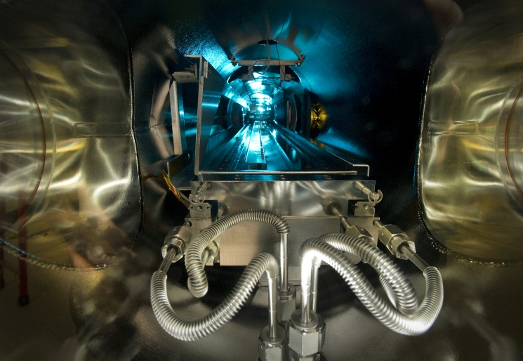 At Brookhaven National Laboratory, scientists have developed a custom-built machine that can grow special lenses, one atomic layer at a time. The machine is as long as an entire room, and scientists use a reprogrammed Xbox controller to direct a transport car through the vacuum-sealed chamber (pictured). The transport car collects plasma-borne particles that form the lenses that will eventually be used to focus high-intensity x-ray beams to reveal the details of nano material structures. <a href="http://www.bnl.gov/ps/news/news.php?a=23511" target="_blank">Learn more about the deposition chamber</a>. | Photo courtesy of Brookhaven National Laboratory. At Brookhaven National Laboratory, scientists have developed a custom-built machine that can grow special lenses, one atomic layer at a time. The machine is as long as an entire room, and scientists use a reprogrammed Xbox controller to direct a transport car through the vacuum-sealed chamber (pictured). The transport car collects plasma-borne particles that form the lenses that will eventually be used to focus high-intensity x-ray beams to reveal the details of nano material structures. <a href="http://www.bnl.gov/ps/news/news.php?a=23511" target="_blank">Learn more about the deposition chamber</a>. | Photo courtesy of Brookhaven National Laboratory.
