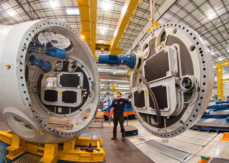 In Jonesboro, Arkansas, a Nordex USA employee stands between utility-scale components that will eventually make up a completed wind turbine. Under the Recovery Act, Nordex USA received a tax credit to assist in the creation of the Jonesboro manufacturing facility, which opened in October 2010. | Photo courtesy of Nordex USA.