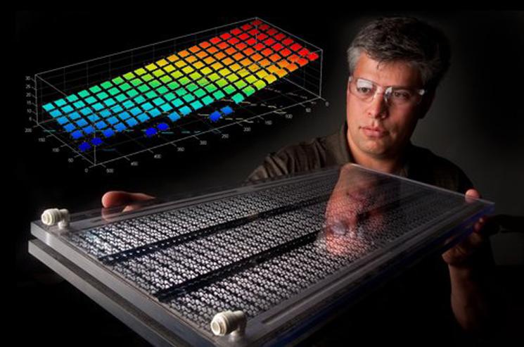 National Renewable Energy Laboratory engineer Eric Kozubal examines a prototype air flow channel of the DEVAP, a novel concept that uses membrane technology to combine the efficiency of evaporative cooling and the drying potential of liquid desiccant salt solutions. The graph superimposed on the photo shows shows how hot humid air, in red, changes to cool dry air, in blue, as the air passes through the core. National Renewable Energy Laboratory engineer Eric Kozubal examines a prototype air flow channel of the DEVAP, a novel concept that uses membrane technology to combine the efficiency of evaporative cooling and the drying potential of liquid desiccant salt solutions. The graph superimposed on the photo shows shows how hot humid air, in red, changes to cool dry air, in blue, as the air passes through the core.