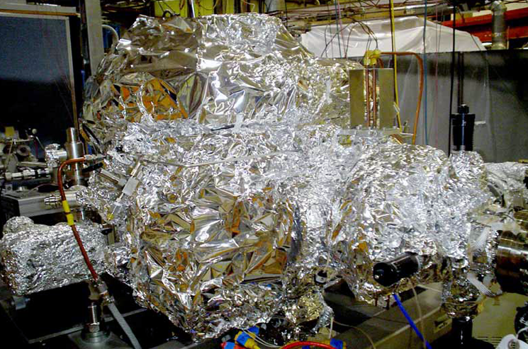 SLAC National Accelerator Laboratory uses massive quantities of aluminum foil to perform "bake out" of their equipment. In a typical bake out, the equipment is blanketed in foil, wrapped with electrical heat tape, and then covered in foil again. Heat tape is used to heat the metal chamber just enough to loosen any residues that could cause trouble. The aluminum foil helps spread the heat evenly. | Photo of SLAC SLAC National Accelerator Laboratory uses massive quantities of aluminum foil to perform "bake out" of their equipment. In a typical bake out, the equipment is blanketed in foil, wrapped with electrical heat tape, and then covered in foil again. Heat tape is used to heat the metal chamber just enough to loosen any residues that could cause trouble. The aluminum foil helps spread the heat evenly. | Photo of SLAC