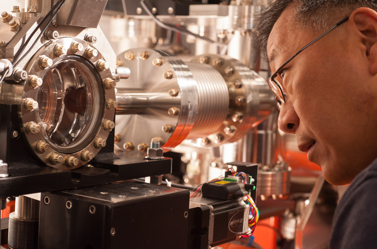 SLAC staff scientist Yiping Feng examines a chamber at LCLS' Front End Enclosure, where a thin crystal spectrometer is installed to measure the shot-by-shot characteristics of X-ray laser pulses. | SLAC National Accelerator Photo by Matt Beardsley SLAC staff scientist Yiping Feng examines a chamber at LCLS' Front End Enclosure, where a thin crystal spectrometer is installed to measure the shot-by-shot characteristics of X-ray laser pulses. | SLAC National Accelerator Photo by Matt Beardsley