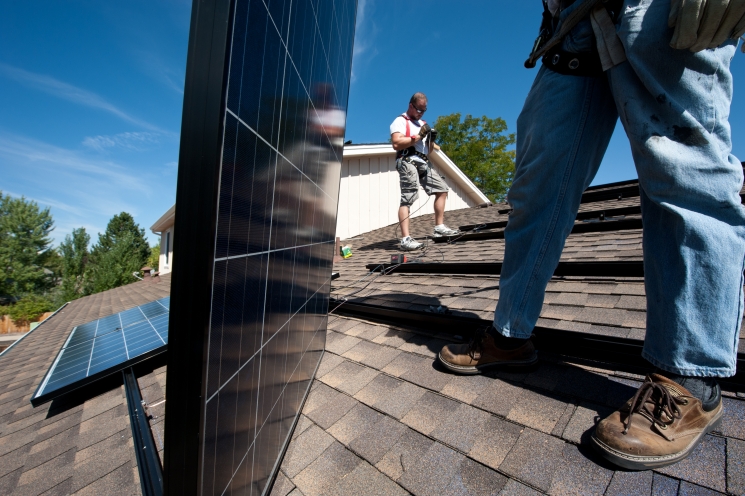 Brian Webster (left) and Mario Richard install photovoltaic modules on an Englewood, Colorado, home. | Photo by Dennis Schroeder, NREL. Brian Webster (left) and Mario Richard install photovoltaic modules on an Englewood, Colorado, home. | Photo by Dennis Schroeder, NREL.