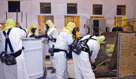 Crews repackage waste from a fiberglass-reinforced plywood box into a container that can be shipped to WIPP. Crews repackage waste from a fiberglass-reinforced plywood box into a container that can be shipped to WIPP.