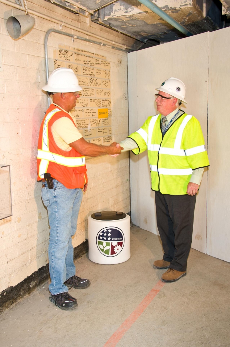Marc Sharpe, who was a senior reactor operator at P Reactor in the mid-1980s, carries a time capsule containing items that reveal Site and national current events into P Reactor. Dr. David Moody, U.S. Department of Energy-Savannah River Operation Office Manager, is walking behind him. Marc Sharpe, who was a senior reactor operator at P Reactor in the mid-1980s, carries a time capsule containing items that reveal Site and national current events into P Reactor. Dr. David Moody, U.S. Department of Energy-Savannah River Operation Office Manager, is walking behind him.