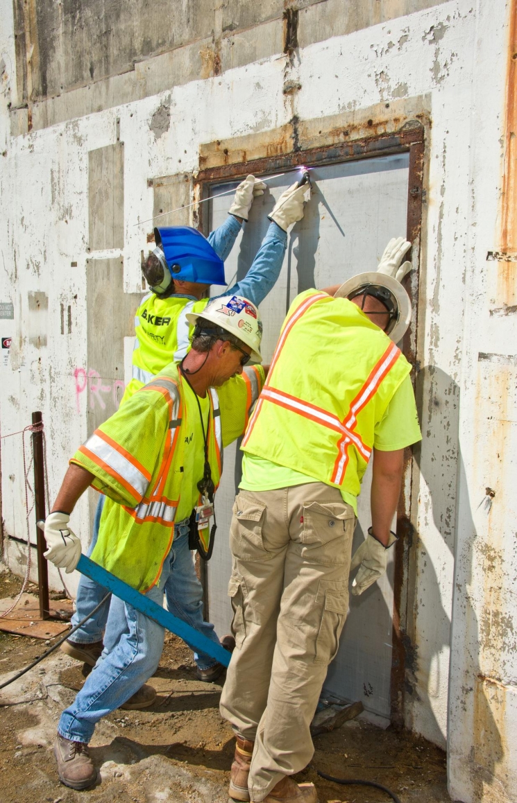 From left, Baker Concrete’s Charles Powell, Archie Jarrell, and Michael Carter weld shut the last opening to the P Reactor 105-P building. Baker performed the in situ grouting of the below-grade areas. From left, Baker Concrete’s Charles Powell, Archie Jarrell, and Michael Carter weld shut the last opening to the P Reactor 105-P building. Baker performed the in situ grouting of the below-grade areas.