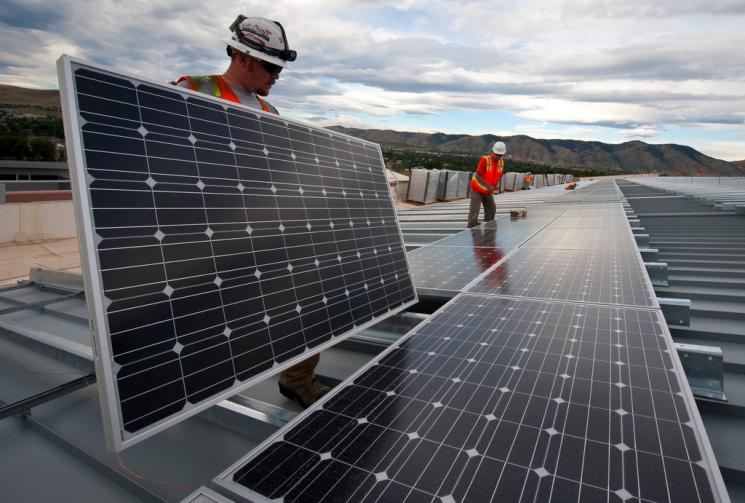 Brian Lawson and Kenesaw Burwell install solar panels at the Energy Department's Research Support Facility -- a highly efficient building at the National Renewable Energy Laboratory in Golden, Colorado. | Credit: Dennis Schroeder, NREL.