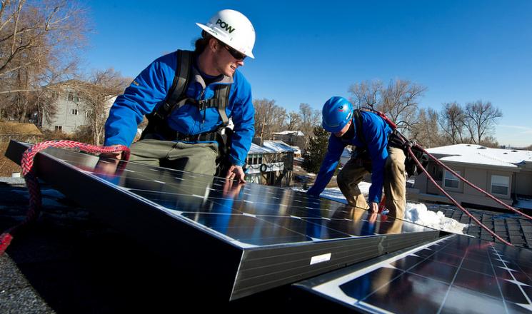 Kyle Travis, left and Jon Jackson, with Lighthouse Solar, install microcrystalline PV modules on top of Kevin Donovan's town home. | Credit: Dennis Schroeder. Kyle Travis, left and Jon Jackson, with Lighthouse Solar, install microcrystalline PV modules on top of Kevin Donovan's town home. | Credit: Dennis Schroeder.