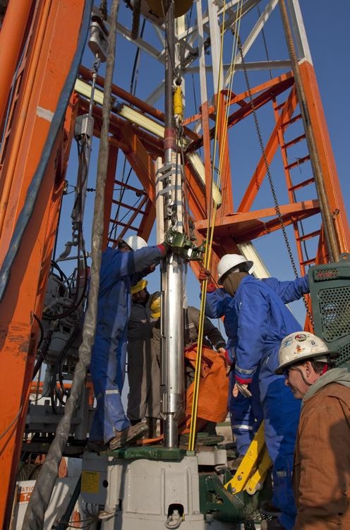 Schlumberger technicians and rig crew lowering monitoring instrumentation into a well. | Photo credit to the Illinois State Geological Survey. Schlumberger technicians and rig crew lowering monitoring instrumentation into a well. | Photo credit to the Illinois State Geological Survey.