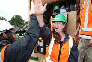 Amanda Crosby, right, and Belinda Dods of New Zealand celebrate placing the final screw on the deck of their house at Solar Decathlon 2011. Amanda Crosby, right, and Belinda Dods of New Zealand celebrate placing the final screw on the deck of their house at Solar Decathlon 2011.