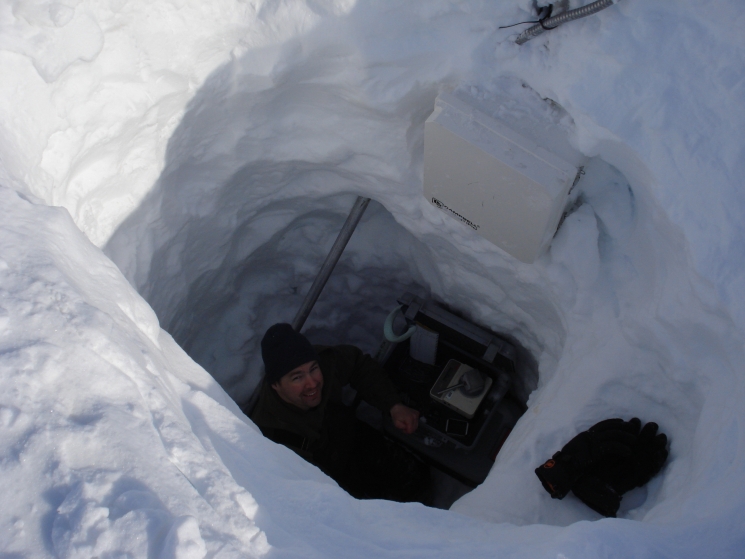 Researcher Joel Bailey measures the density of the snow in this snow pit to determine the amount of snow in the drift and the water equivalent of the snow drift.