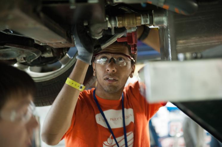 A North Carolina State University student works on an EcoCAR vehicle at the Year 3 finals last year in Milford, MI. | Energy Department photo.
A North Carolina State University student works on an EcoCAR vehicle at the Year 3 finals last year in Milford, MI. | Energy Department photo.