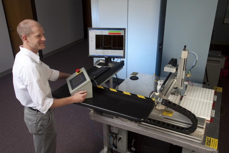 Application Engineer Eric Biedermann of Vibrant supervises an automated nondestructive testing system. | Photo courtesy of Sandia National Lab. Application Engineer Eric Biedermann of Vibrant supervises an automated nondestructive testing system. | Photo courtesy of Sandia National Lab.