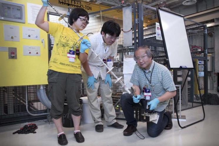 Maiko Kofu, Atsushi Nagoe and Osamu Yamamuro examine their sample attached to the end of the cryostat stick after running an experiment at Oak Ridge National Laboratory’s Spallation Neutron Source. | Department of Energy Photo | Courtesy of Oak Ridge National Laboratory | Public Domain | Maiko Kofu, Atsushi Nagoe and Osamu Yamamuro examine their sample attached to the end of the cryostat stick after running an experiment at Oak Ridge National Laboratory’s Spallation Neutron Source. | Department of Energy Photo | Courtesy of Oak Ridge National Laboratory | Public Domain |
