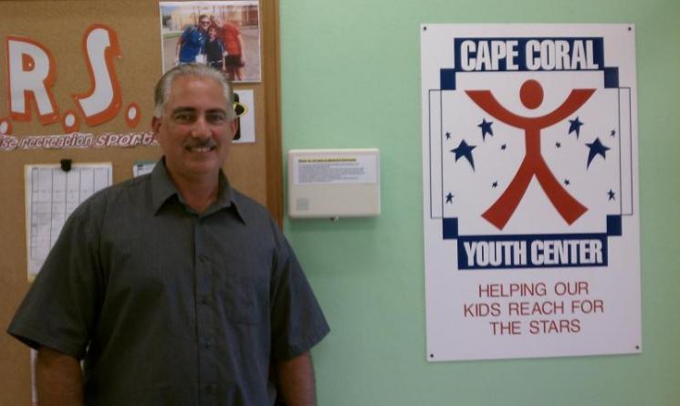  Cape Coral Youth Center Manager Mark Cagel stands in front of a tamper-proof thermostat at the Austen Youth Center in Cape Coral, Florida. | Photo Courtesy of the Cape Coral Youth Center