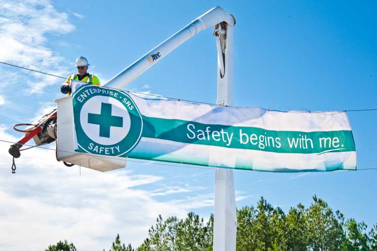 A Savannah River Nuclear Solutions employee hangs one of several “Safety Begins with Me” banners near a Savannah River Site entrance. A Savannah River Nuclear Solutions employee hangs one of several “Safety Begins with Me” banners near a Savannah River Site entrance.