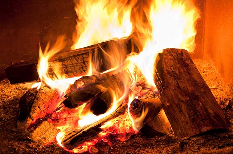 Burning firewood can keep you warm and cozy while keeping your thermostat and electricity use low. | Photo courtesy of ©iStockphoto.com/Pgiam. Burning firewood can keep you warm and cozy while keeping your thermostat and electricity use low. | Photo courtesy of ©iStockphoto.com/Pgiam.