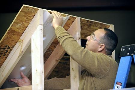 Daniel Tello demonstrates how to prepare an attic space for insulation using skills learned from the First Choice Program. | Photo courtesy of HCDC, Human Capital Development Corp., Inc. and Scott Anderson Daniel Tello demonstrates how to prepare an attic space for insulation using skills learned from the First Choice Program. | Photo courtesy of HCDC, Human Capital Development Corp., Inc. and Scott Anderson