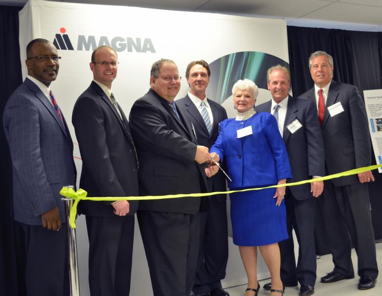 Vehicle Technologies Program Manager Patrick B. Davis gets ready to cut the ribbon at Magna E-Car's new electric drive component plant in Michigan. From left: Mike Finney - CEO, Michigan Economic Development Corporation; Gary Meyers - VP/General Manager, Magna E-Car USA, LP; Pat Davis; Kevin Pavlov - Chief Operating Officer, Magna E-Car Systems; Marilyn Hoffman, Township Supervisor, Grand Blanc Township, Michigan; Joseph Graves, State Representative 51st District, Michigan House of Representatives; Tim Herman, CEO, The Genesee County Chamber of Commerce. | Photo courtesy of Magna E-Car. 