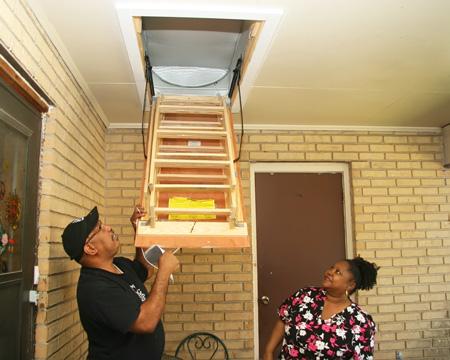 SMILE Weatherization Coordinator Venice Roberts shows client Shelia Sturgis an attic tent, which conserves energy and decreases costs. | Photo by Susannah Malbreau SMILE Weatherization Coordinator Venice Roberts shows client Shelia Sturgis an attic tent, which conserves energy and decreases costs. | Photo by Susannah Malbreau