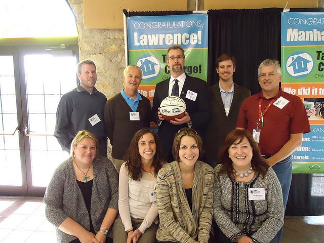 The Lawrence Community team, leadership pictured above, saved the highest total amount of any community. They hold a basketball signed by Kansas Governor Brownback. The basketball signifies both the sport's history in Kansas, as well as the fact that the average Kansas home has enough energy leaks in their home to equal a basketball-sized hole in their roof. The Lawrence Community team, leadership pictured above, saved the highest total amount of any community. They hold a basketball signed by Kansas Governor Brownback. The basketball signifies both the sport's history in Kansas, as well as the fact that the average Kansas home has enough energy leaks in their home to equal a basketball-sized hole in their roof.