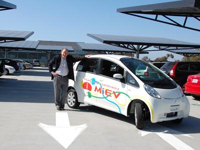Byron Washom, Director of Strategic Energy Initiatives at the University of California at San Diego, poses with an electric vehicle and some of the solar panels that cover UCSD's campus.| Photo courtesy of UCSD Byron Washom, Director of Strategic Energy Initiatives at the University of California at San Diego, poses with an electric vehicle and some of the solar panels that cover UCSD's campus.| Photo courtesy of UCSD