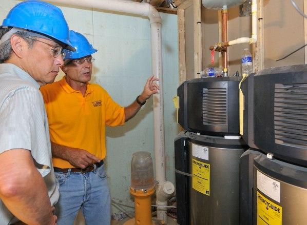 Sec. Chu observes as workers demonstrate energy efficient water heaters. | Department of Energy Photo | Courtesy of National Renewable Energy Laboratory | Sec. Chu observes as workers demonstrate energy efficient water heaters. | Department of Energy Photo | Courtesy of National Renewable Energy Laboratory |