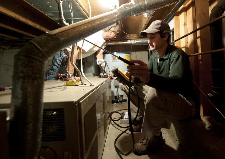 Olaf Sander and Zump Urycki evaluate the heating system of a home in Loveland, Colorado, as part of the Weatherization Assistance Program. | Credit: Dennis Schroeder, NREL. Olaf Sander and Zump Urycki evaluate the heating system of a home in Loveland, Colorado, as part of the Weatherization Assistance Program. | Credit: Dennis Schroeder, NREL.