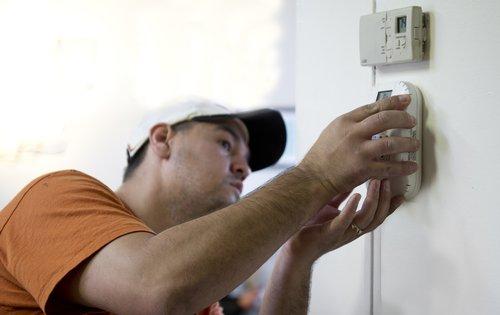 Brian Bernal installs a carbon monoxide detector for a homeowner participating in the Weatherization Assistance Program in Loveland, CO. | Credit: Dennis Schroeder, NREL. Brian Bernal installs a carbon monoxide detector for a homeowner participating in the Weatherization Assistance Program in Loveland, CO. | Credit: Dennis Schroeder, NREL.
