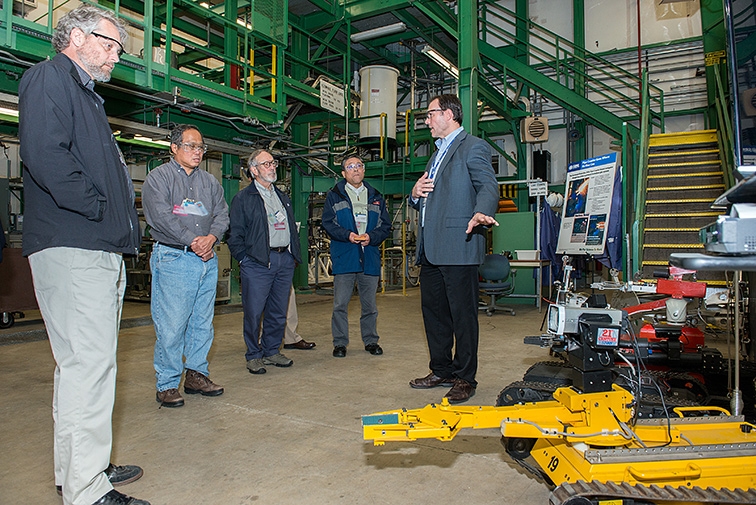 Mitch Pryor, University of Texas – Austin, left to right, Wendall Chun, University of Colorado – Denver, Bill Hamel, University of Tennessee, and Satoshi Tadokoro, Tohuku University, Japan, listen as Tom Nance, Savannah River National Laboratory, explains cleanup mission uses for various robots.