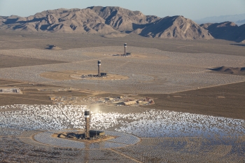 Located in the Mojave Desert, 40 miles southwest of Las Vegas, the Ivanpah Solar Electric Generating System is the largest solar thermal energy facility in the world, with 392 MW of capacity â meaning it can produce enough renewable electricity to power nearly 100,000 homes. It uses 173,500 heliostat mirrors spread over approximately 3,500 acres, focusing solar energy on boilers located atop three solar power towers, generating steam to turn a conventional steam turbine. The facility is owned by NRG Solar, Google and BrightSource Energy. The Energy Department provided a $1.6 billion loan guarantee to the project.
Pictured here is an aerial perspective of the nearly completed Ivanpah Solar Power Facility, taken in April 2013. | Photo courtesy of Gilles Mingasson/Getty Images for Bechtel. Located in the Mojave Desert, 40 miles southwest of Las Vegas, the Ivanpah Solar Electric Generating System is the largest solar thermal energy facility in the world, with 392 MW of capacity â meaning it can produce enough renewable electricity to power nearly 100,000 homes. It uses 173,500 heliostat mirrors spread over approximately 3,500 acres, focusing solar energy on boilers located atop three solar power towers, generating steam to turn a conventional steam turbine. The facility is owned by NRG Solar, Google and BrightSource Energy. The Energy Department provided a $1.6 billion loan guarantee to the project.
Pictured here is an aerial perspective of the nearly completed Ivanpah Solar Power Facility, taken in April 2013. | Photo courtesy of Gilles Mingasson/Getty Images for Bechtel.