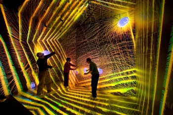 Over the past several years, Los Alamos National Laboratory has invested in providing state-of-the-art tools to help scientists understand and explore their data.
In this photo, researchers are investigating the details of an astronomical simulation in the CAVE (cave automatic virtual environment) -- a cube-shaped room with high-resolution projections on all six surfaces. Using 3D glasses, these researchers can see objects floating in air, and even walk around the objects, allowing them to observe simulations from all angles. | Photo by LeRoy Sanchez, LANL. Over the past several years, Los Alamos National Laboratory has invested in providing state-of-the-art tools to help scientists understand and explore their data.
In this photo, researchers are investigating the details of an astronomical simulation in the CAVE (cave automatic virtual environment) -- a cube-shaped room with high-resolution projections on all six surfaces. Using 3D glasses, these researchers can see objects floating in air, and even walk around the objects, allowing them to observe simulations from all angles. | Photo by LeRoy Sanchez, LANL.