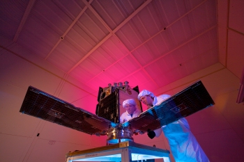 The Cibola Flight Experiment (CFE) is an experimental small satellite that was designed to prove that off-the-shelf computer processors can be used for supercomputing in space. The processors, also called field-programmable gate arrays, can be reconfigured while the satellite is in orbit, enabling researchers to modify them for a variety of tasks like studying lightning, disturbances in the ionosphere, and radio-frequency sources.
The CFE satellite was launched on March 8, 2007, in low-earth orbit, and has operated successfully since its deployment. In this 2006 photo, Los Alamos National Laboratory scientist Daniel Seitz works on preparing the CFE satellite. | Photo by LeRoy Sanchez, Los Alamos National Laboratory. The Cibola Flight Experiment (CFE) is an experimental small satellite that was designed to prove that off-the-shelf computer processors can be used for supercomputing in space. The processors, also called field-programmable gate arrays, can be reconfigured while the satellite is in orbit, enabling researchers to modify them for a variety of tasks like studying lightning, disturbances in the ionosphere, and radio-frequency sources.
The CFE satellite was launched on March 8, 2007, in low-earth orbit, and has operated successfully since its deployment. In this 2006 photo, Los Alamos National Laboratory scientist Daniel Seitz works on preparing the CFE satellite. | Photo by LeRoy Sanchez, Los Alamos National Laboratory.