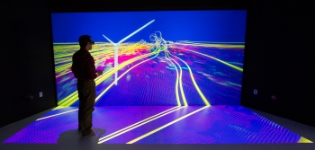At the National Renewables Energy Laboratory (NREL), scientists use the Insight Center Collaboration Room to examine and interact with their data. In this simulation, the room is converted into a virtual wind tunnel, allowing scientists to study the complex, turbulent flow fields around wind turbines.
Pictured here, NREL Senior Scientist Kenny Gruchalla examines the velocity field surrounding a wind turbine, using a 3-D model projected onto the center's 16-by-8 foot wall. The simulation helps scientists better understand flow patterns, and further, how turbines can better avoid gearbox failures. <a href="http://www.nrel.gov/news/features/feature_detail.cfm/feature_id=2254" target="_blank">Learn more about the Insight Center Collaboration Room</a>. | Photo courtesy of Dennis Schroeder, NREL. At the National Renewables Energy Laboratory (NREL), scientists use the Insight Center Collaboration Room to examine and interact with their data. In this simulation, the room is converted into a virtual wind tunnel, allowing scientists to study the complex, turbulent flow fields around wind turbines.
Pictured here, NREL Senior Scientist Kenny Gruchalla examines the velocity field surrounding a wind turbine, using a 3-D model projected onto the center's 16-by-8 foot wall. The simulation helps scientists better understand flow patterns, and further, how turbines can better avoid gearbox failures. <a href="http://www.nrel.gov/news/features/feature_detail.cfm/feature_id=2254" target="_blank">Learn more about the Insight Center Collaboration Room</a>. | Photo courtesy of Dennis Schroeder, NREL.