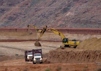 Empty containers on haul trucks are loaded with mill tailings. Empty containers on haul trucks are loaded with mill tailings.